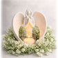 Beautiful memorial angel with a candle surrounded by a floral wreath on a light background