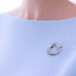 Silver brooch on a light blue garment