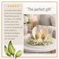 Decorative sympathy gift angel candle holder with angel wings on a table, surrounded by flowers, with text praising its quality and use as a gift.