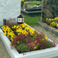 Decorative garden with flowers and a memorial lantern in a cemetery setting