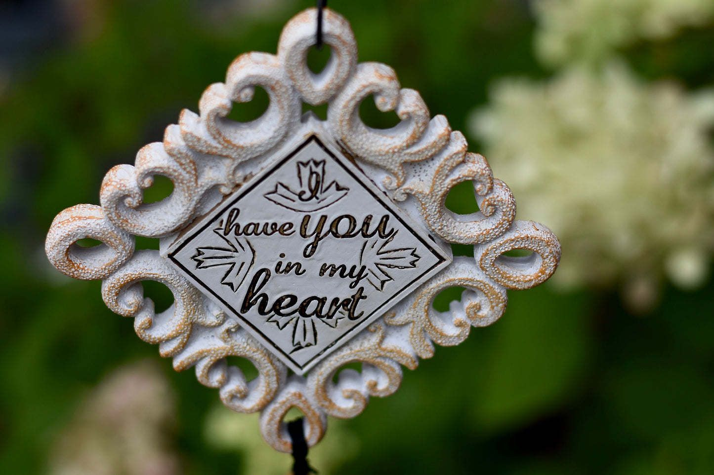 Close-up of memorial wind chime tubes engraved with “So until our heavenly reunion, I have you in my heart”